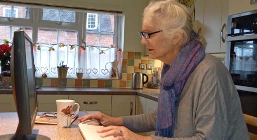 A retirement-age person using a computer in a domestic setting